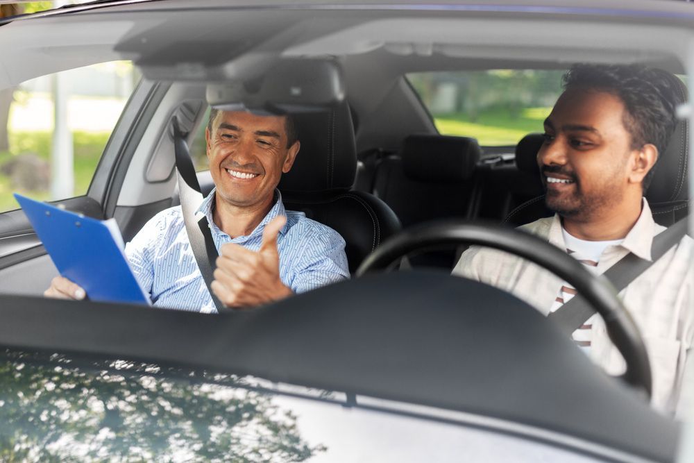 A Man Is Giving a Thumbs up While Sitting in A Car with Another Man — Start Learning Automotive in Brisbane, QLD
