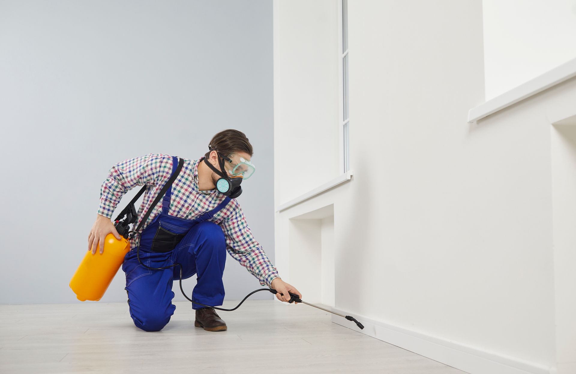 A man is spraying the floor.