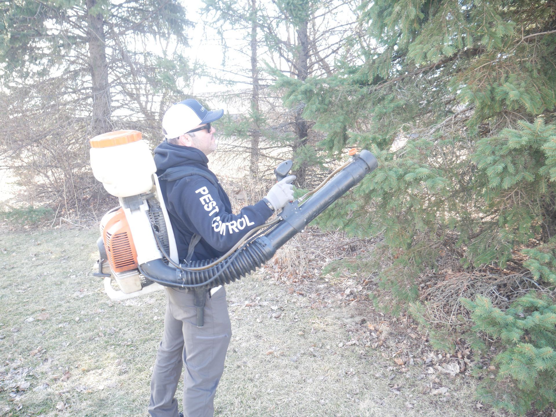 Cory applying mosquito fogger treatment to trees for spring mosquito control at a residential proper