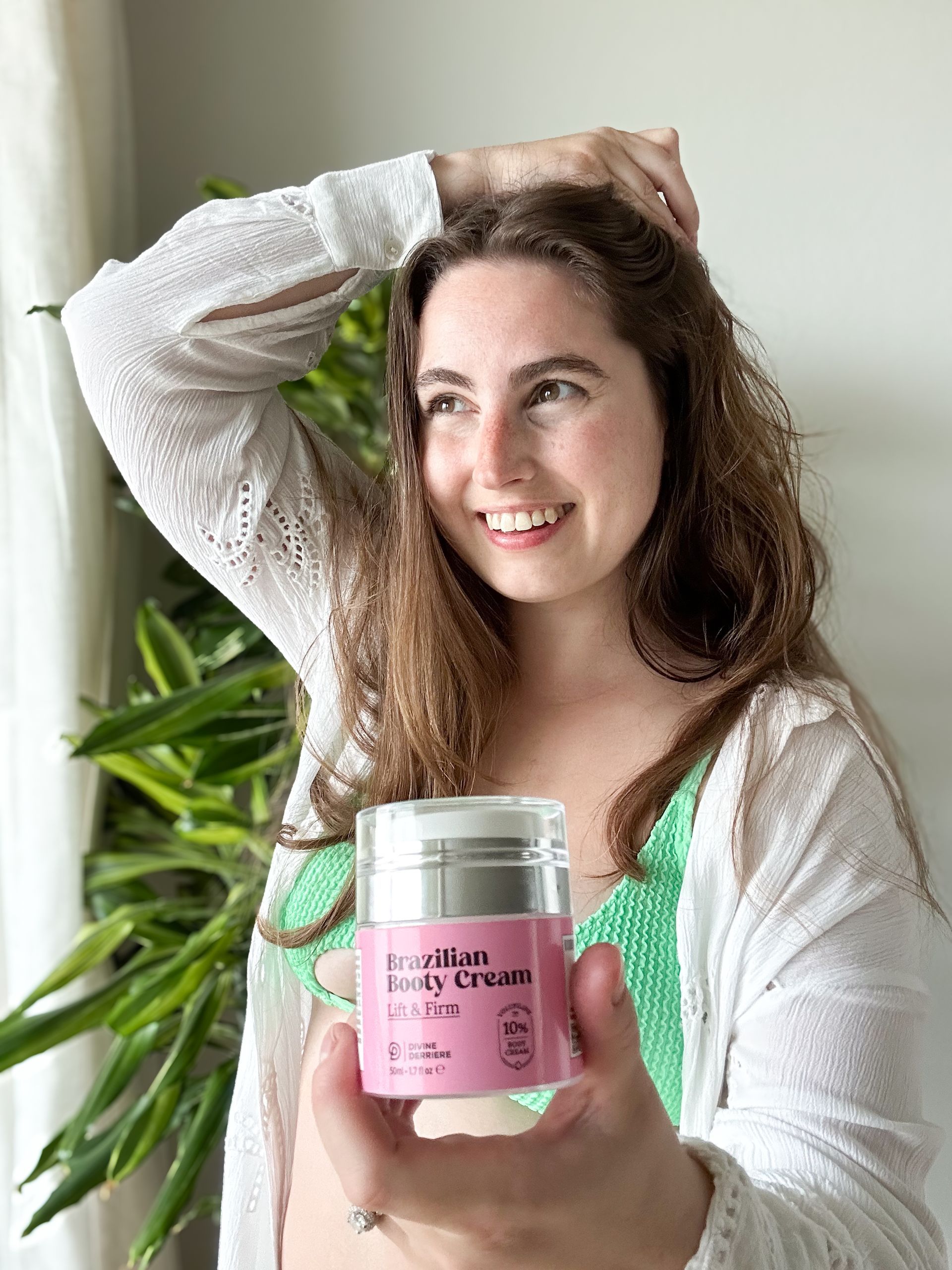 A woman is holding a jar of hair cream in her hand.