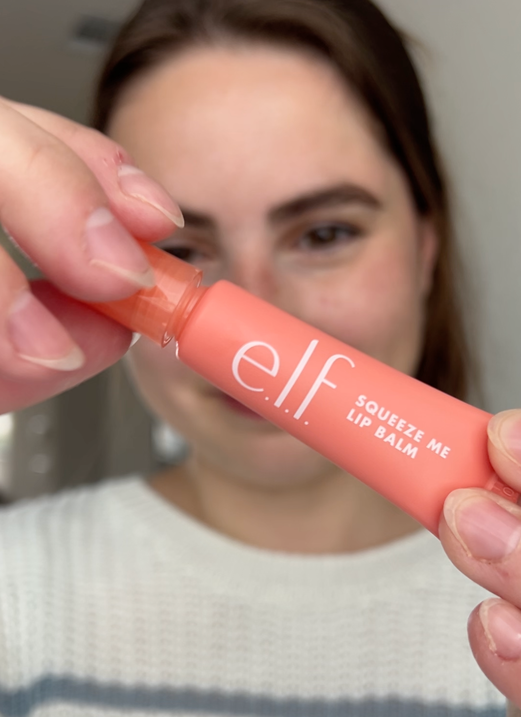 woman holding e.l.f. squeeze me lip balm