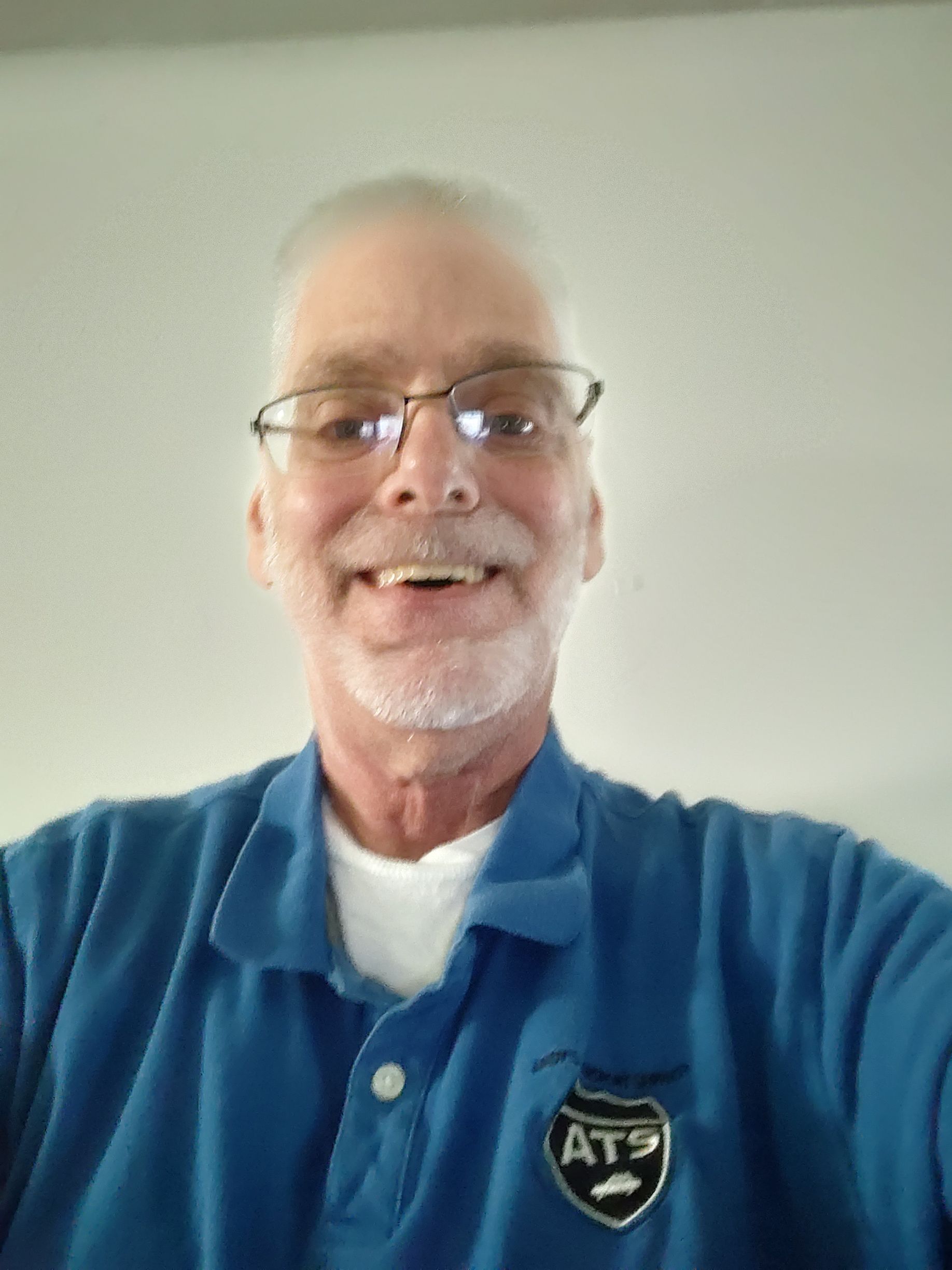 A man wearing glasses and a blue shirt with the word atf on it