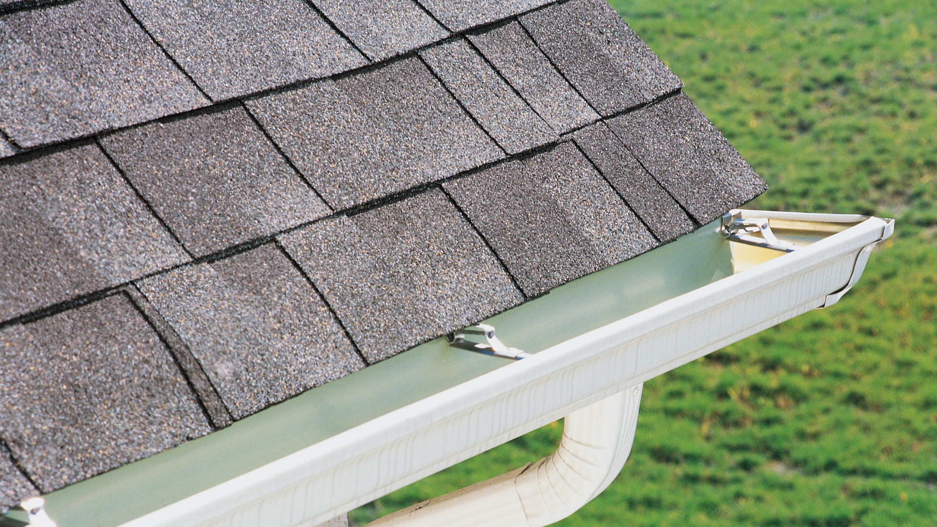 Roof with gray shingles and white gutter.