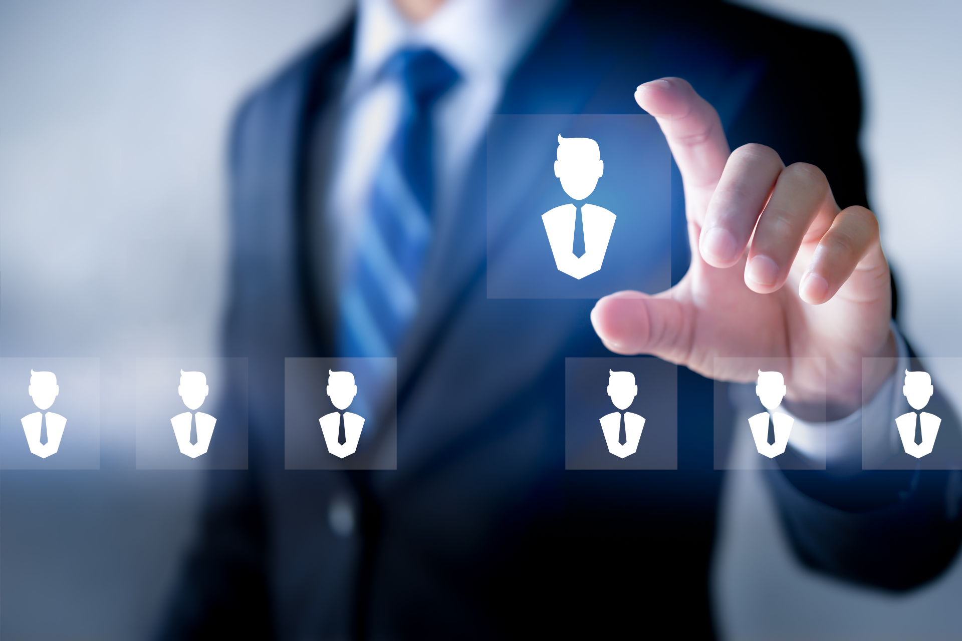 A person in a suit selects a glowing icon of a person from a digital interface.