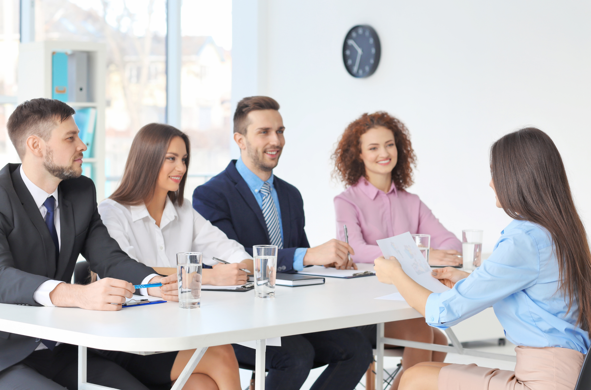 A panel of interviewers interviewing a women.