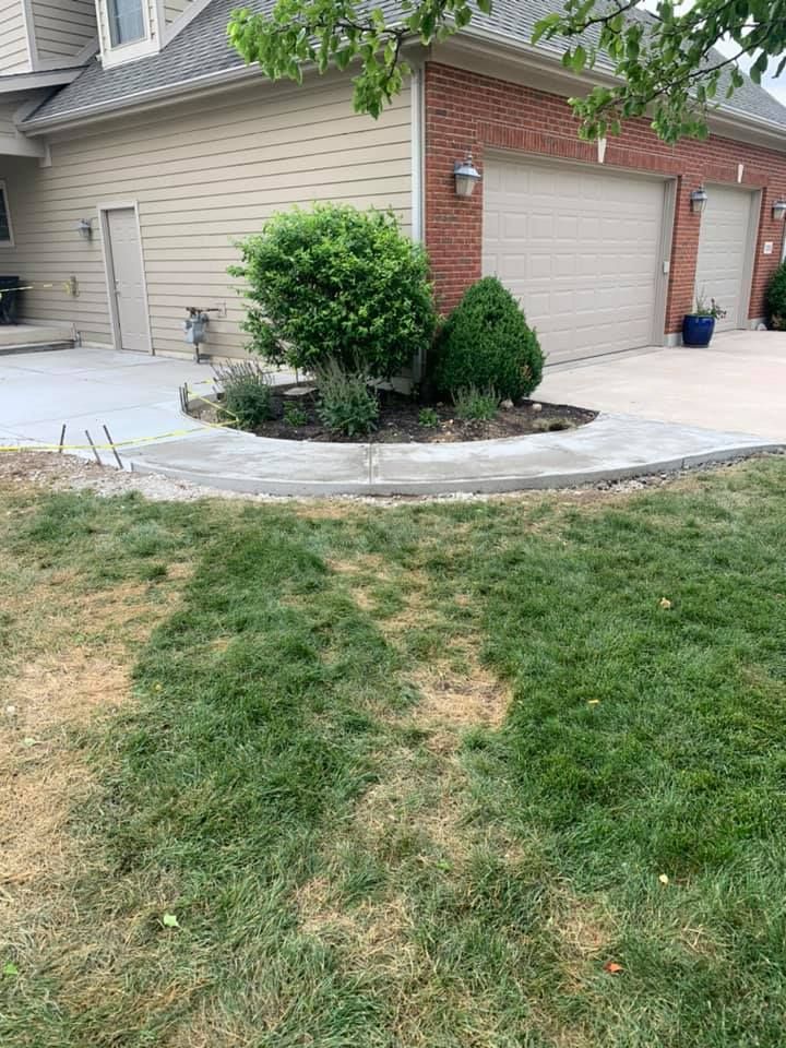 A concrete walkway is being built in front of a house.