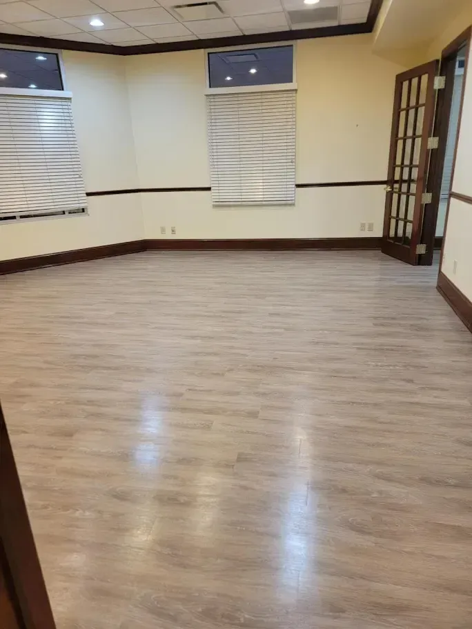 An empty room with a wooden floor and a window.