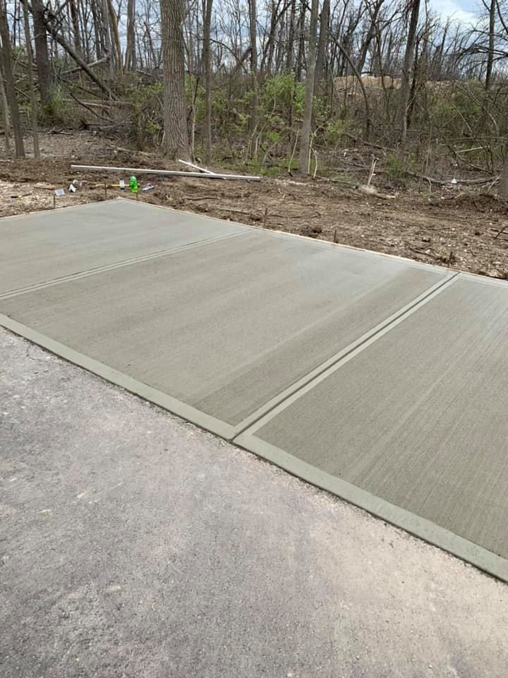 A concrete driveway is being built in the middle of a forest.