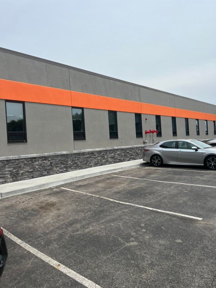 Two cars are parked in front of a large building