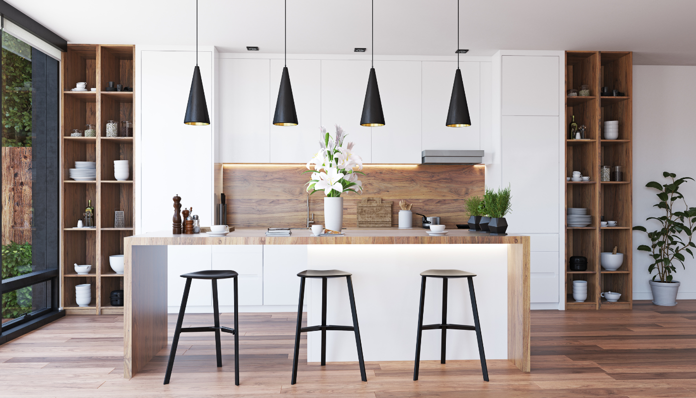 Modern kitchen with a wooden breakfast bar, three black stools, four pendant lights, and built-in shelving units.
