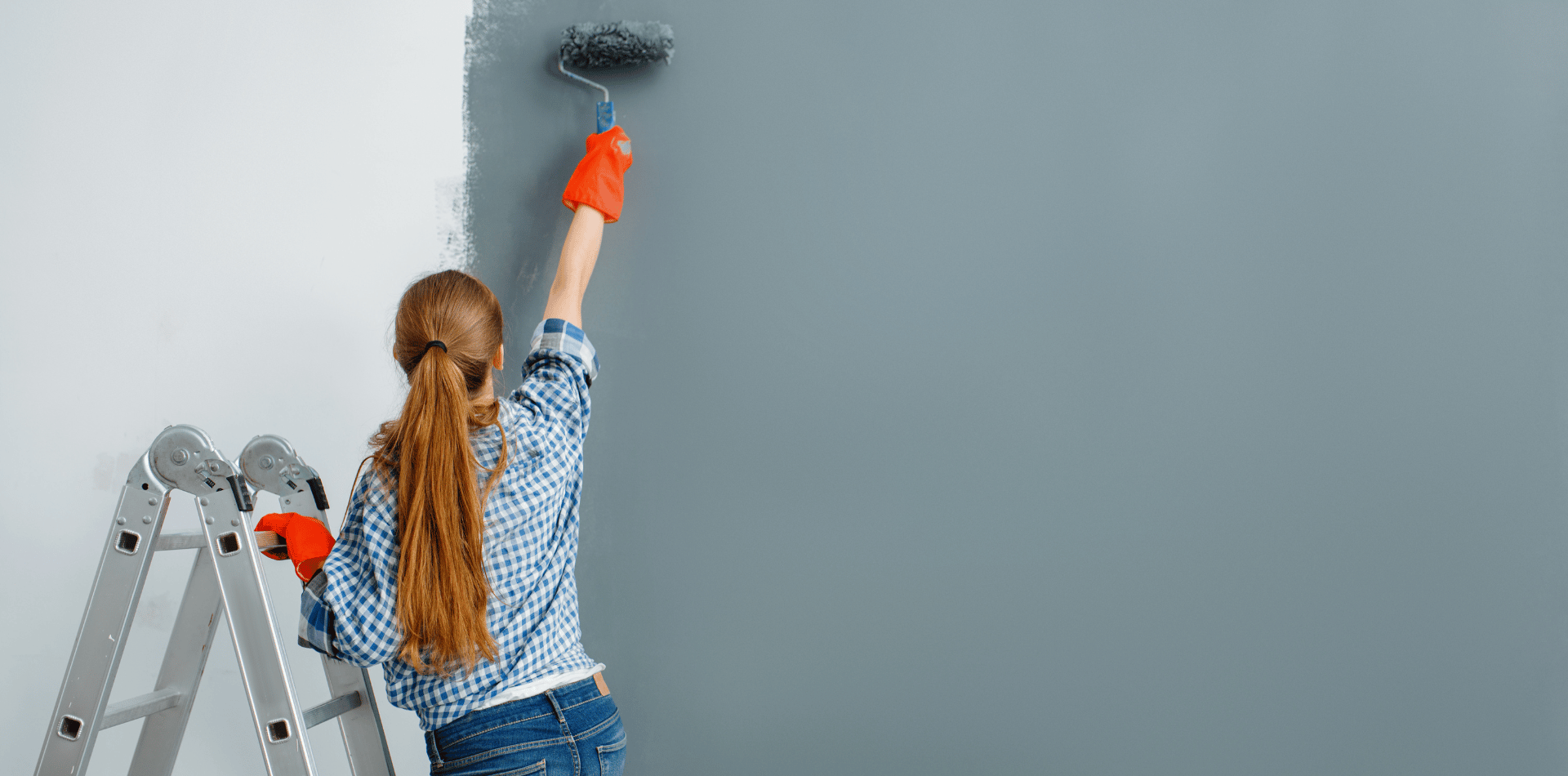 woman DIY painting a dining room wall
