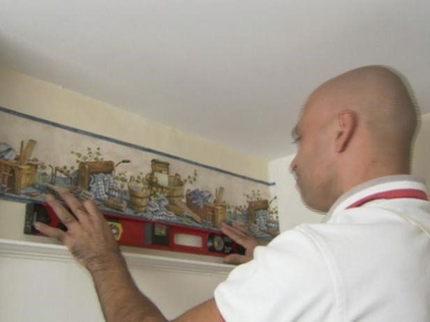 Man checking levels for wallpaper hanging