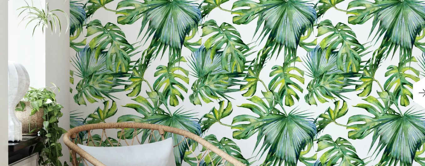 A chair is sitting in front of a wall with tropical leaves on it.