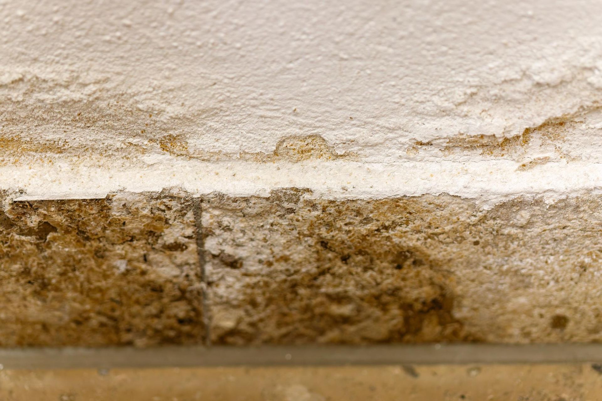 Close-up of a ceiling with water damage and brown stains.