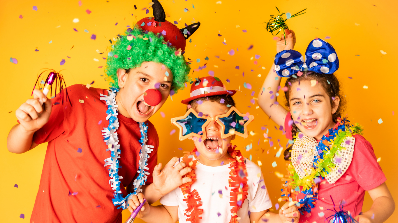 A group of children dressed in clown costumes are standing next to each other.