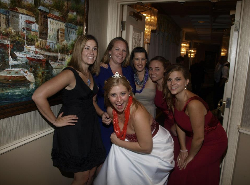 A group of women are posing for a picture in a hallway.