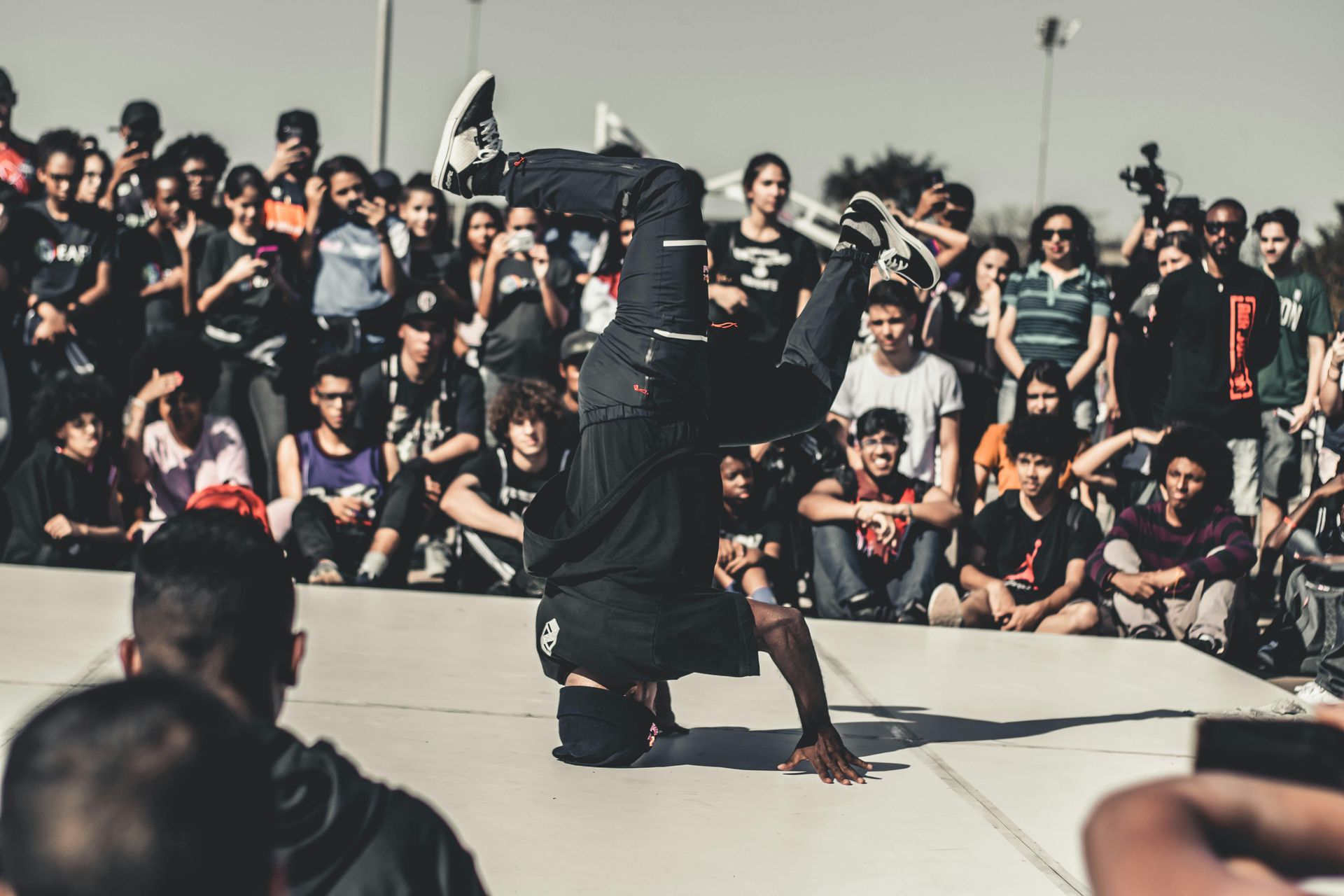 A man is doing a handstand in front of a crowd of people.