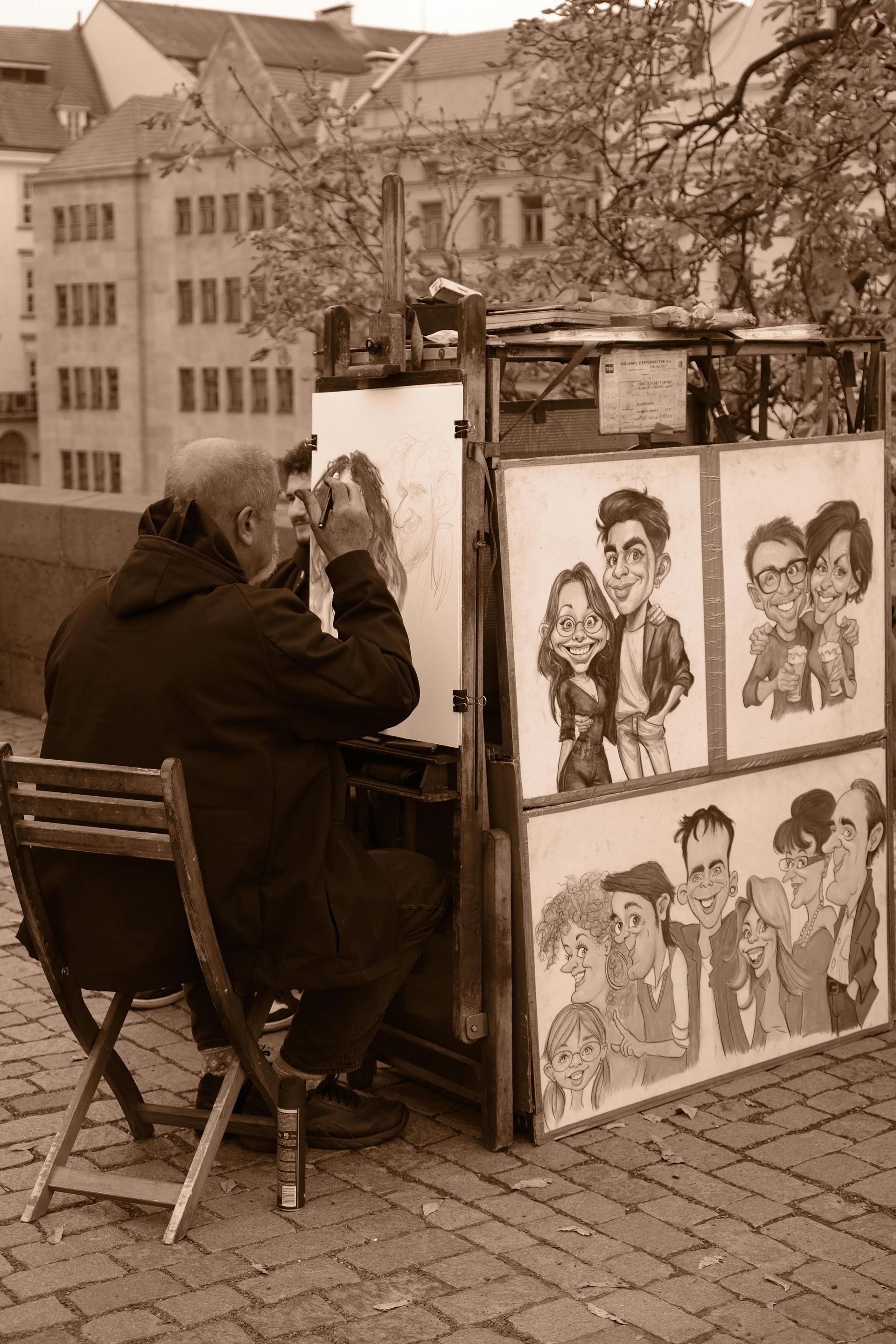 A man is sitting in a chair drawing a caricature of a couple