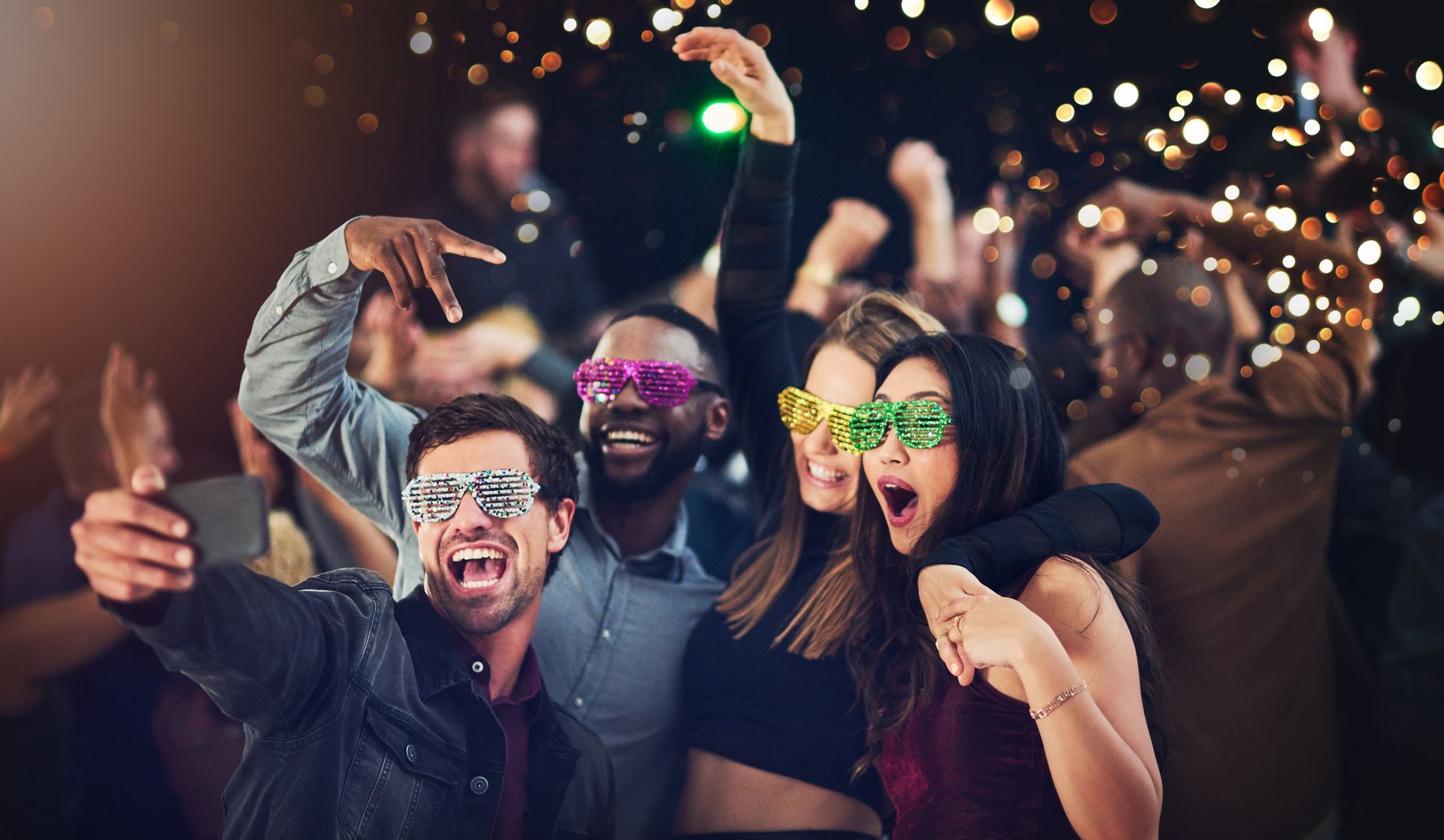 A group of people are taking a selfie at a party.