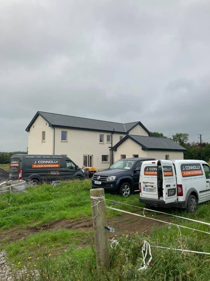 A couple of vans parked in front of a house.