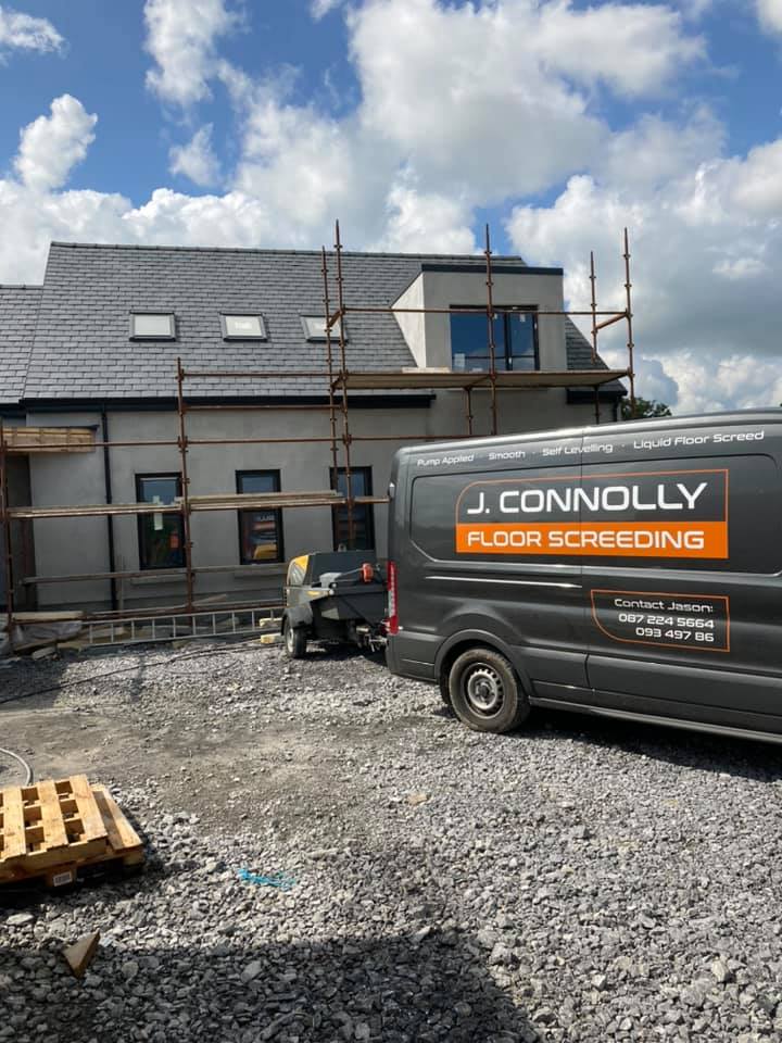 A van is parked in front of a building under construction.
