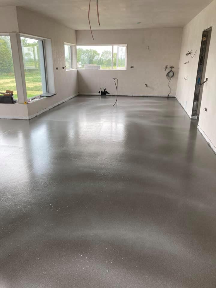 A large room with a concrete floor and a window.
