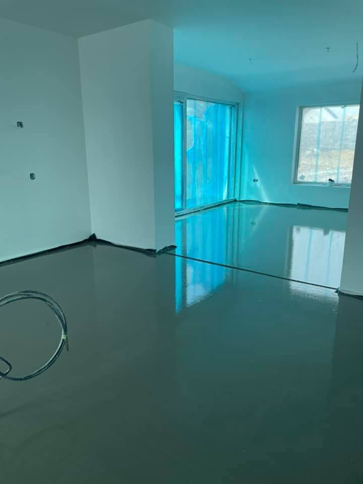 A large empty room with a lot of windows and a concrete floor.