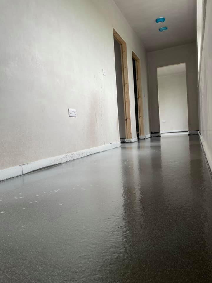 A long hallway with a gray floor and white walls.