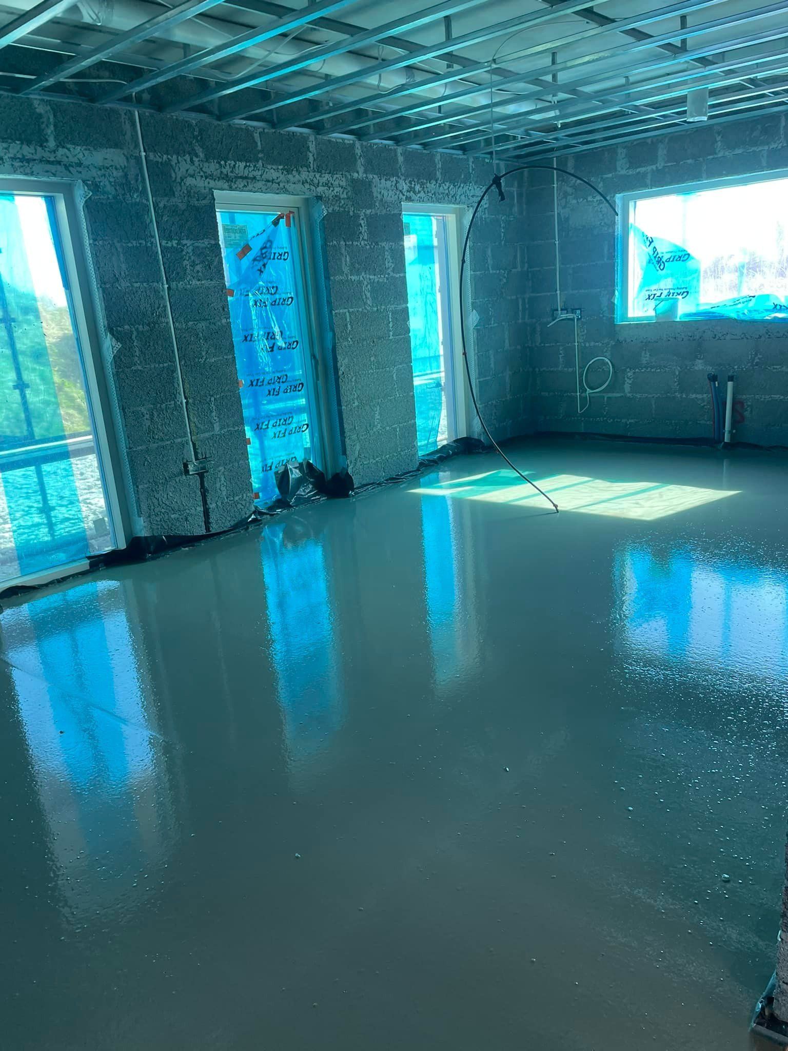 A room with a lot of windows and a concrete floor.