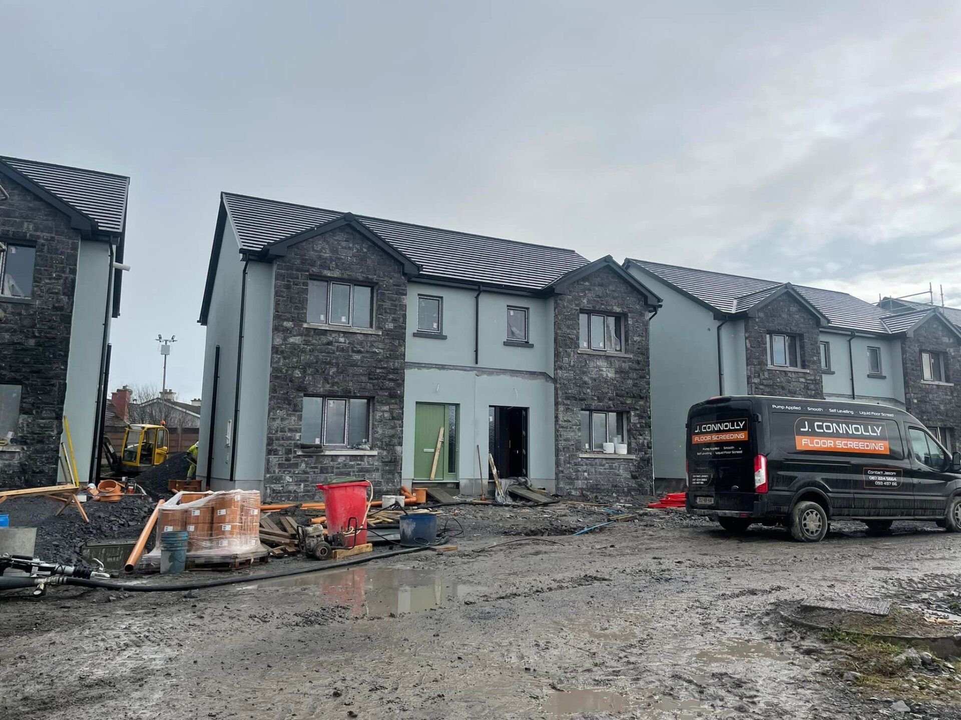 A van is parked in front of a building under construction.