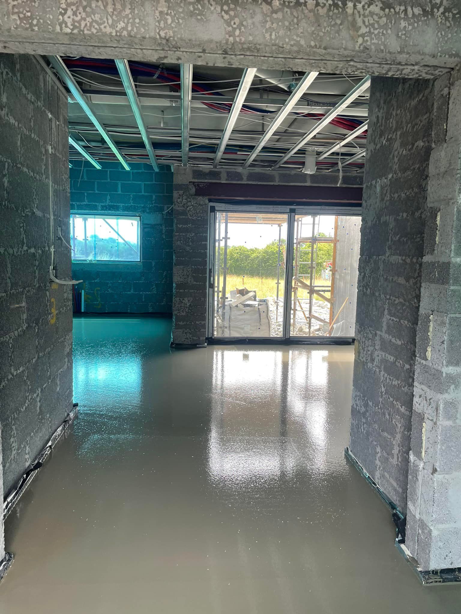 A hallway in a building under construction with a sliding glass door.