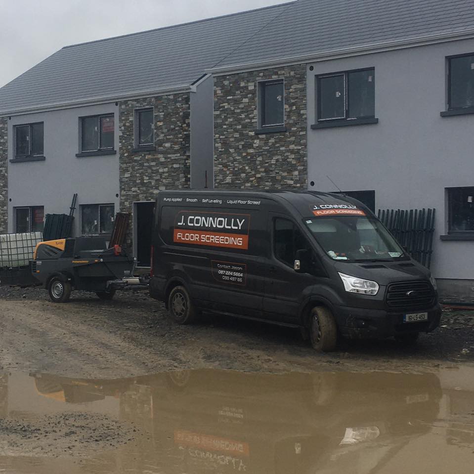 A black van that says a connolly is parked in front of a building