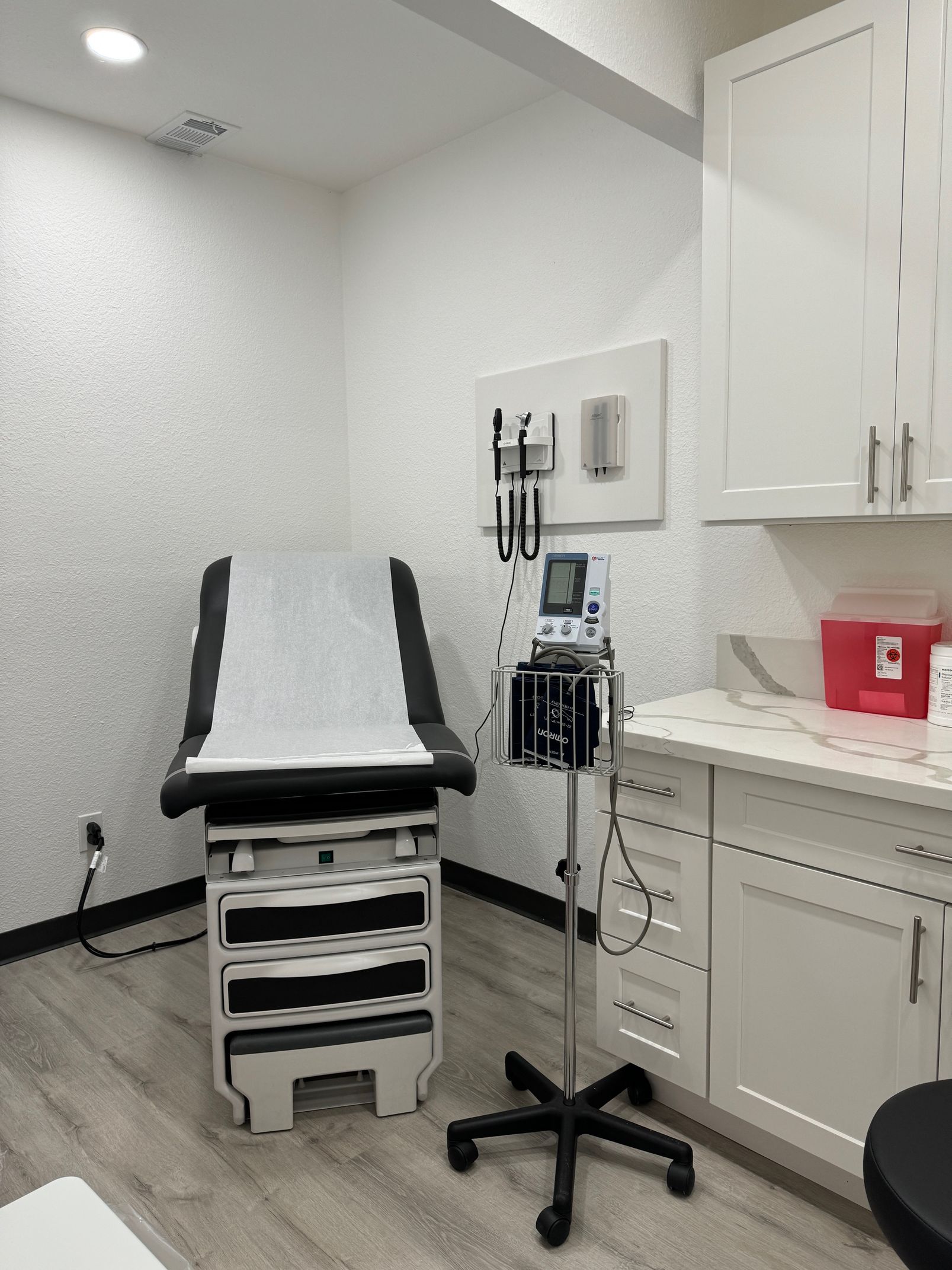 inside the doctors office is an examination chair on the left and on the right is the sphygmomanometer and counter