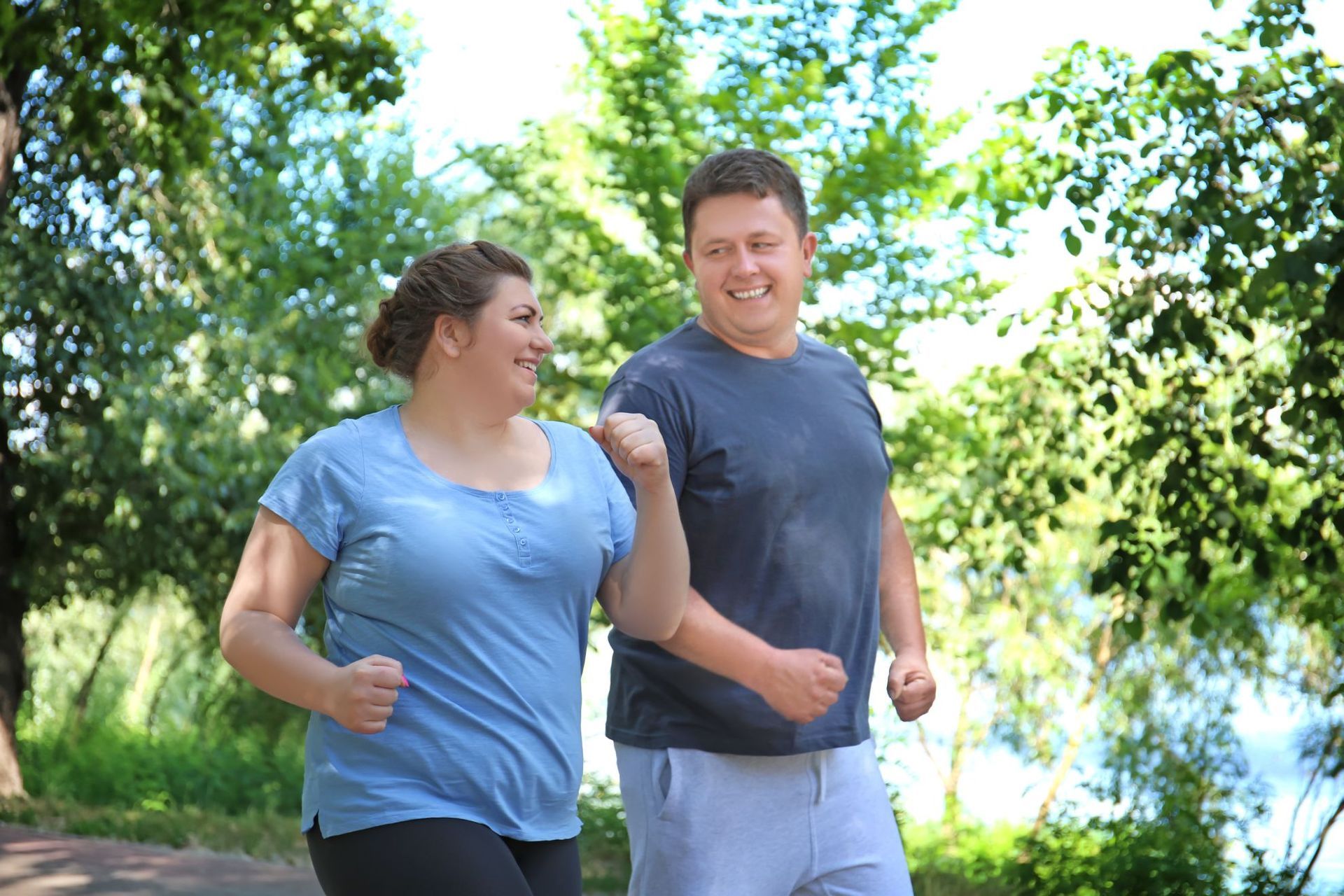 overweight couple jogging in park