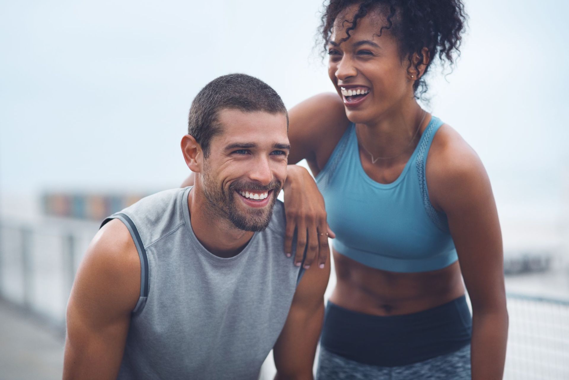 athletic man and woman laughing together
