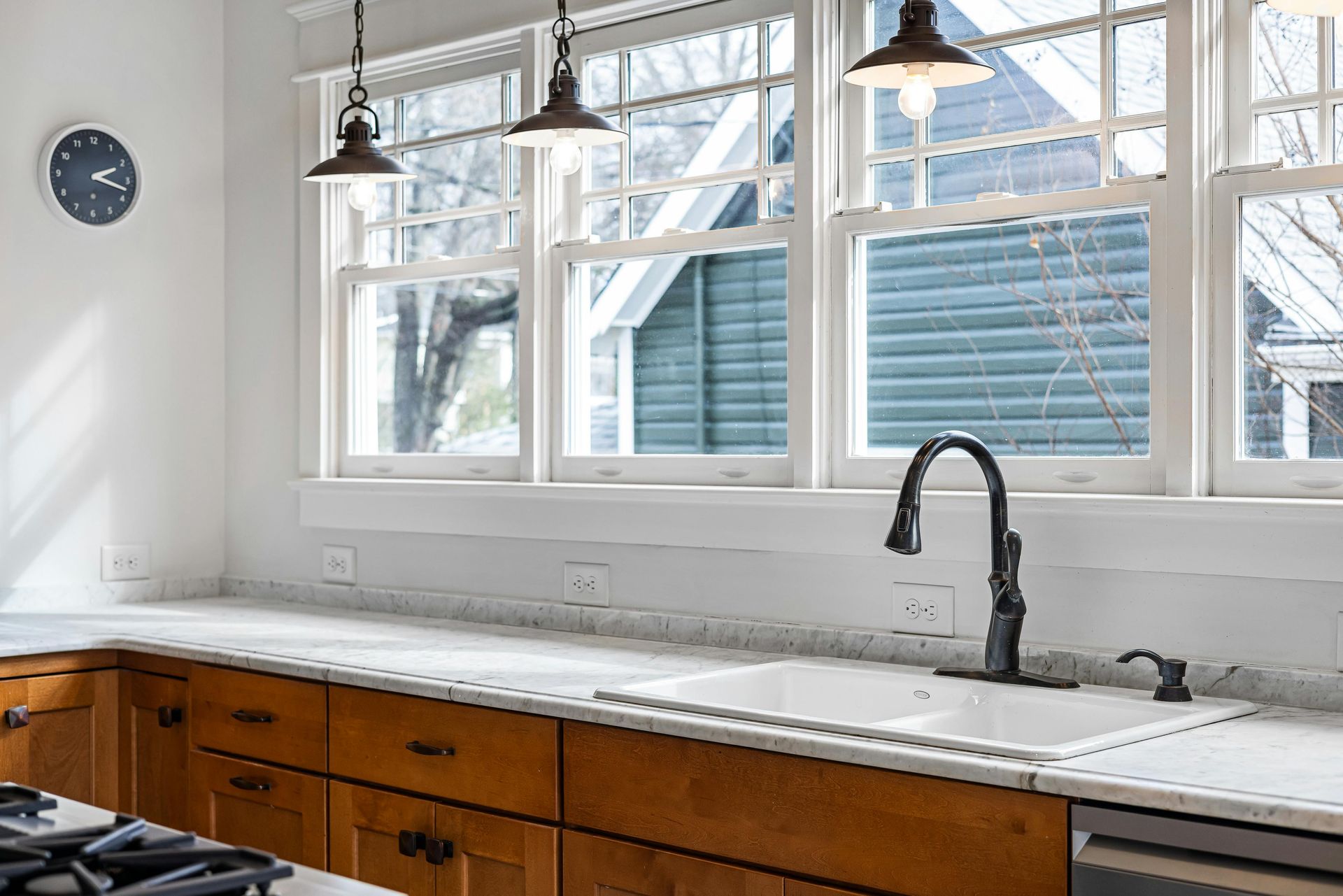Double hung replacement windows in modern kitchen above sink with white frames and energy efficient 
