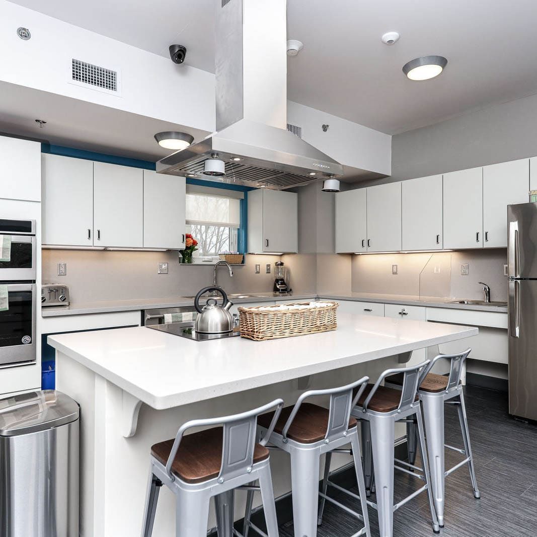 A kitchen with white cabinets and stainless steel appliances