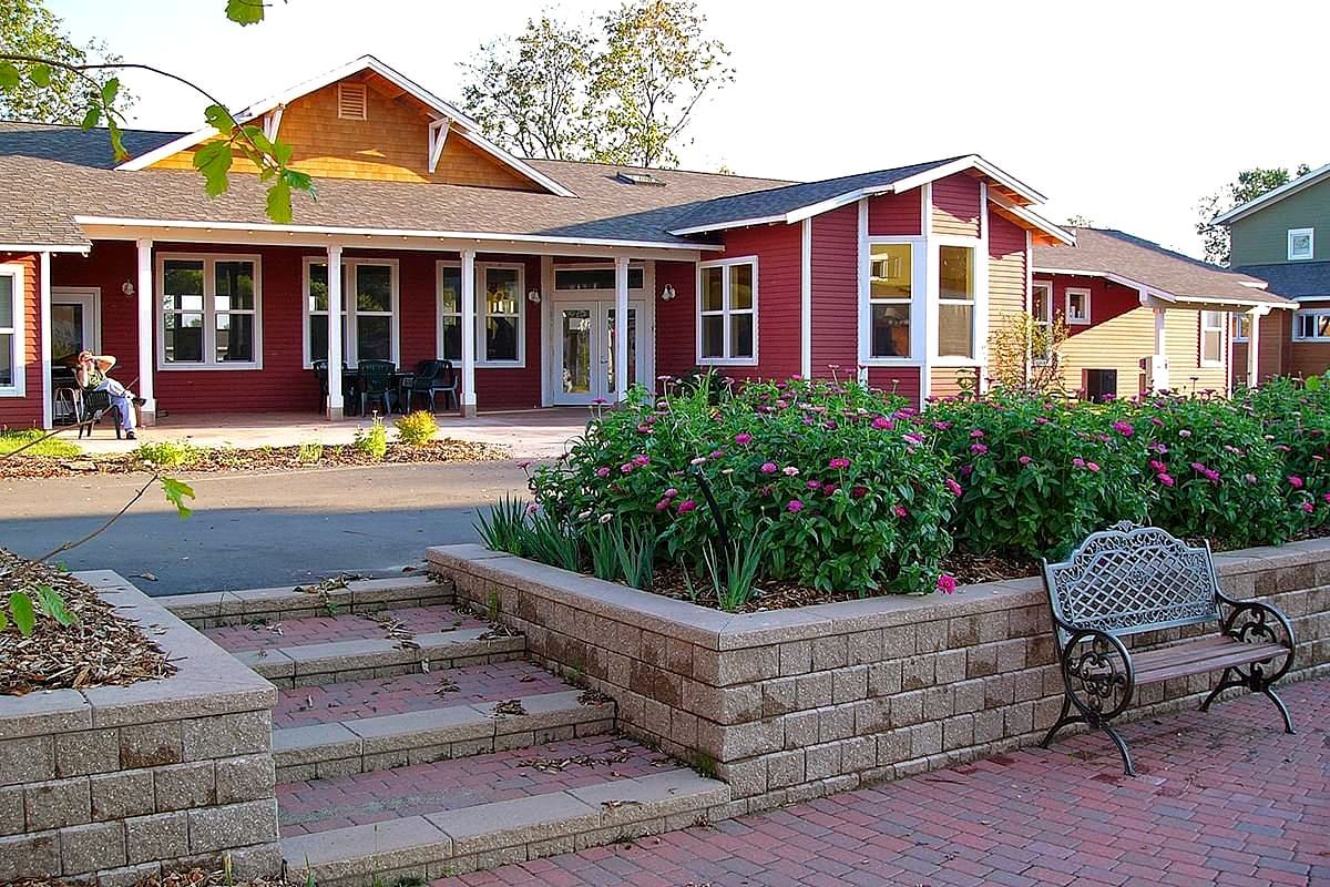A red house with a bench in front of it