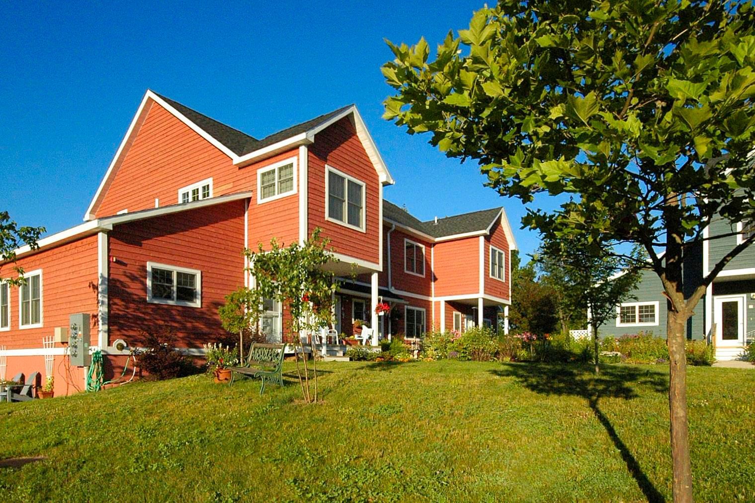 A large red brick house with a tree in front of it