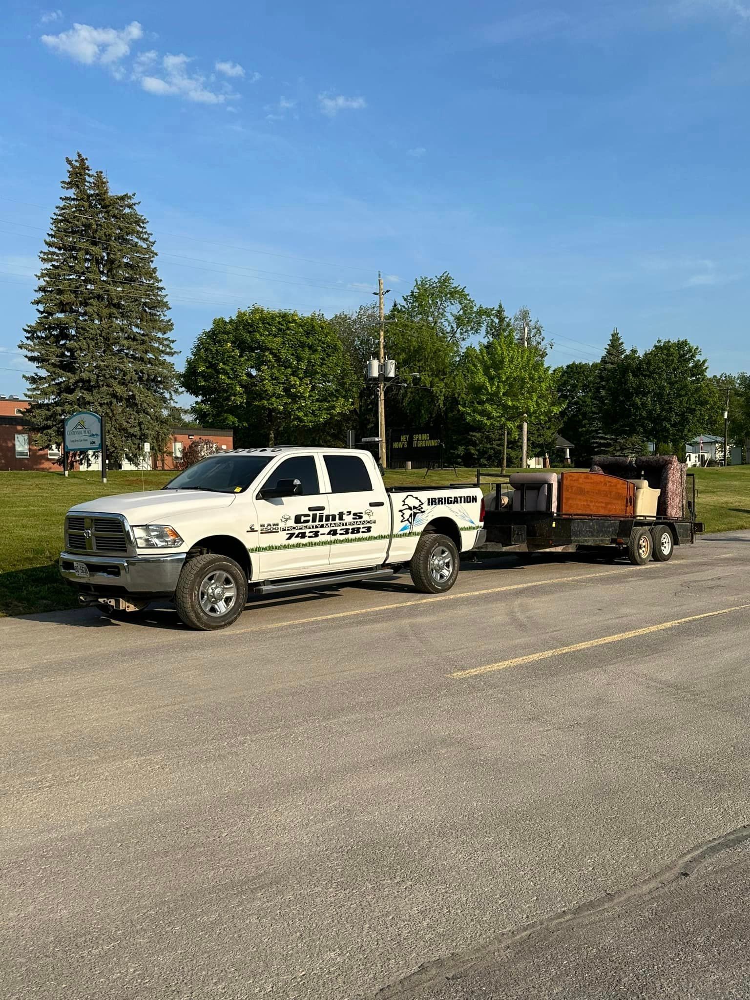 Two white trucks are parked next to each other on the side of the road.