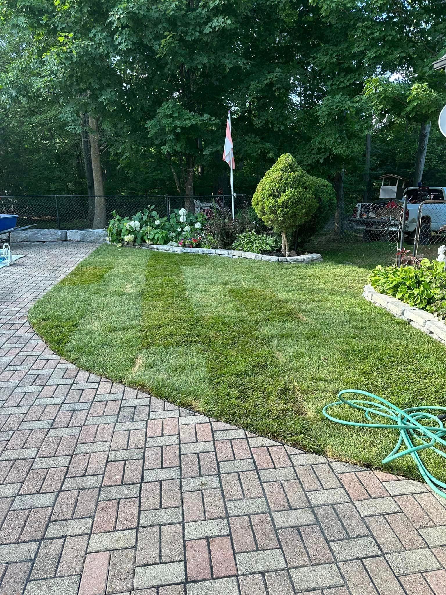 A brick walkway leading to a lush green lawn.