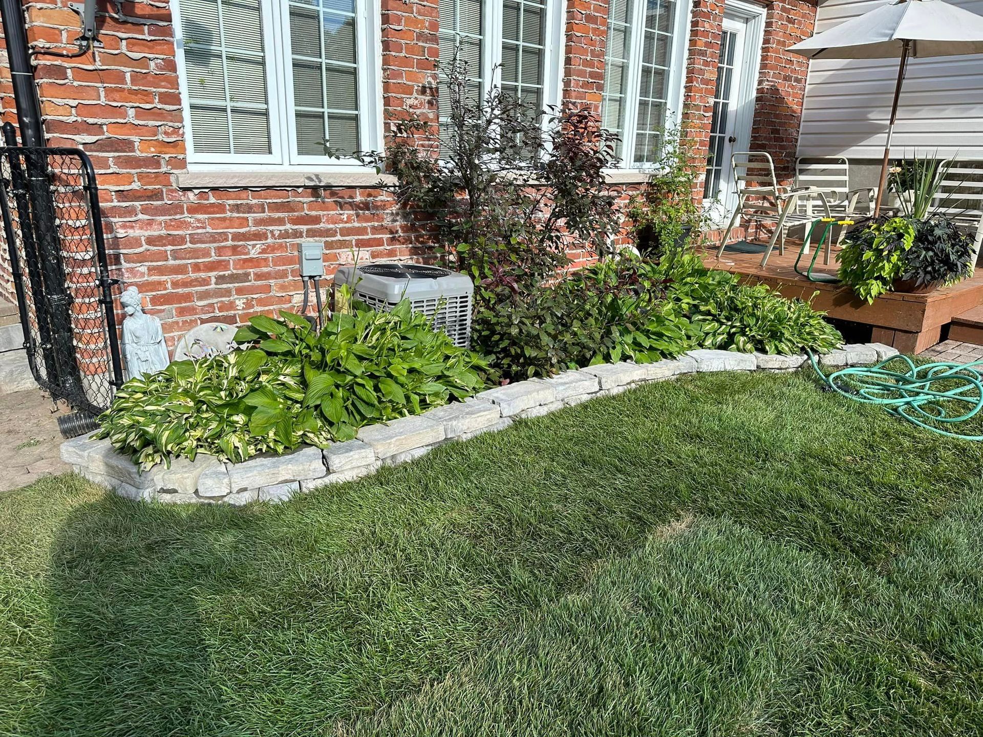 A brick house with a lush green lawn in front of it.
