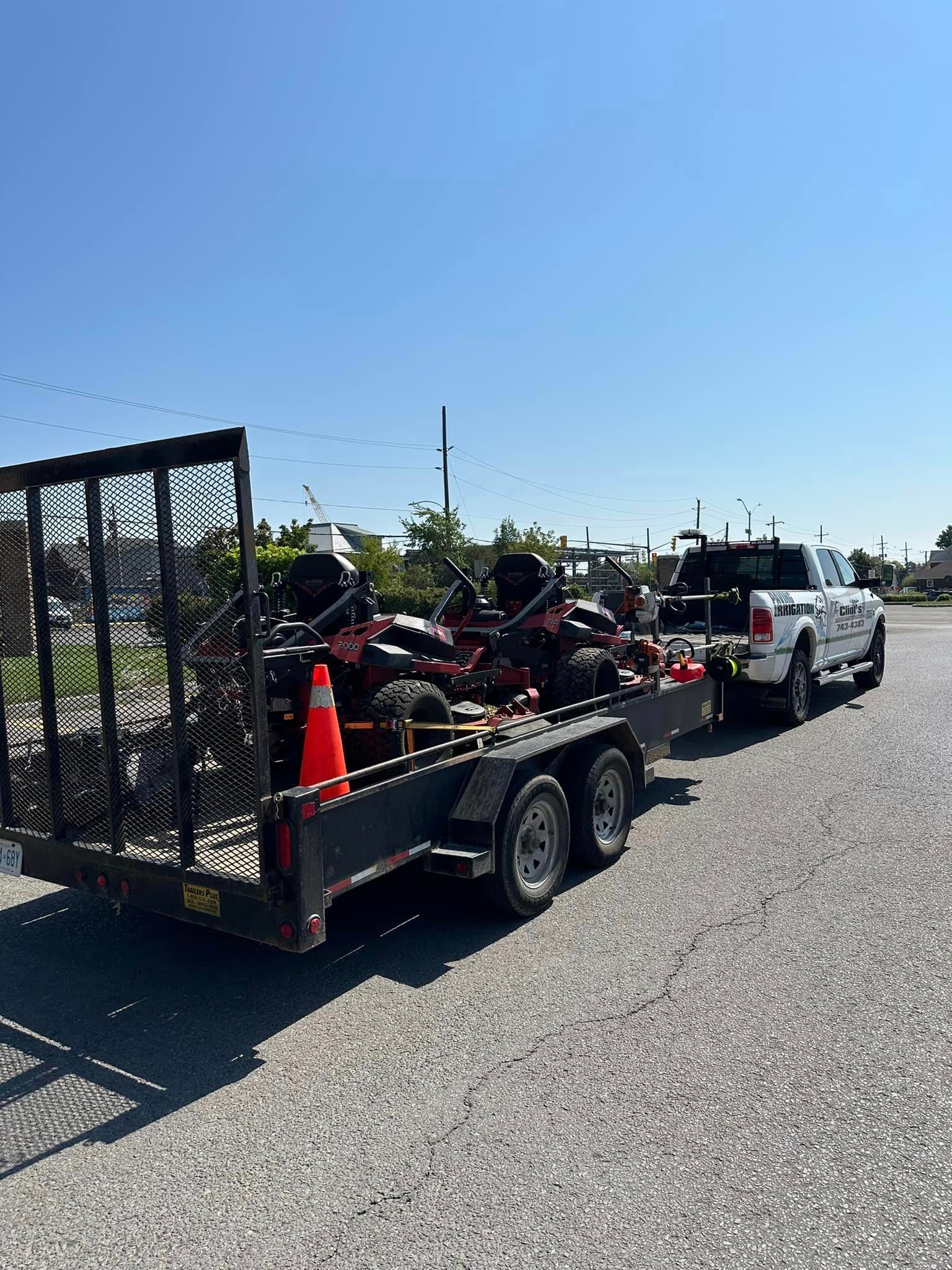 A truck is towing a trailer with a motorcycle on it.