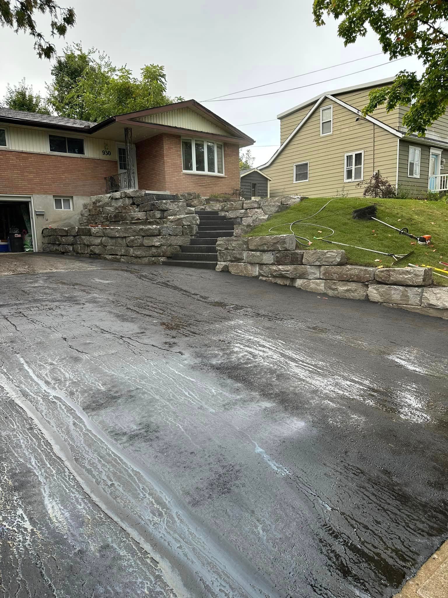 A house with a large driveway and stairs in front of it.