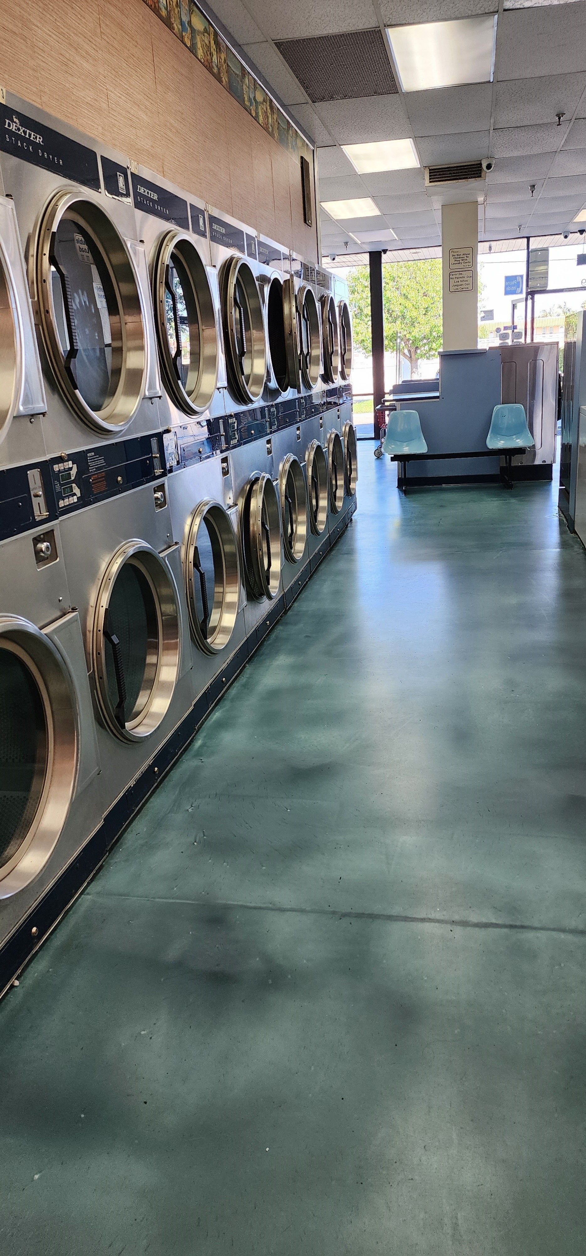 Three washing machines are lined up in a laundromat.