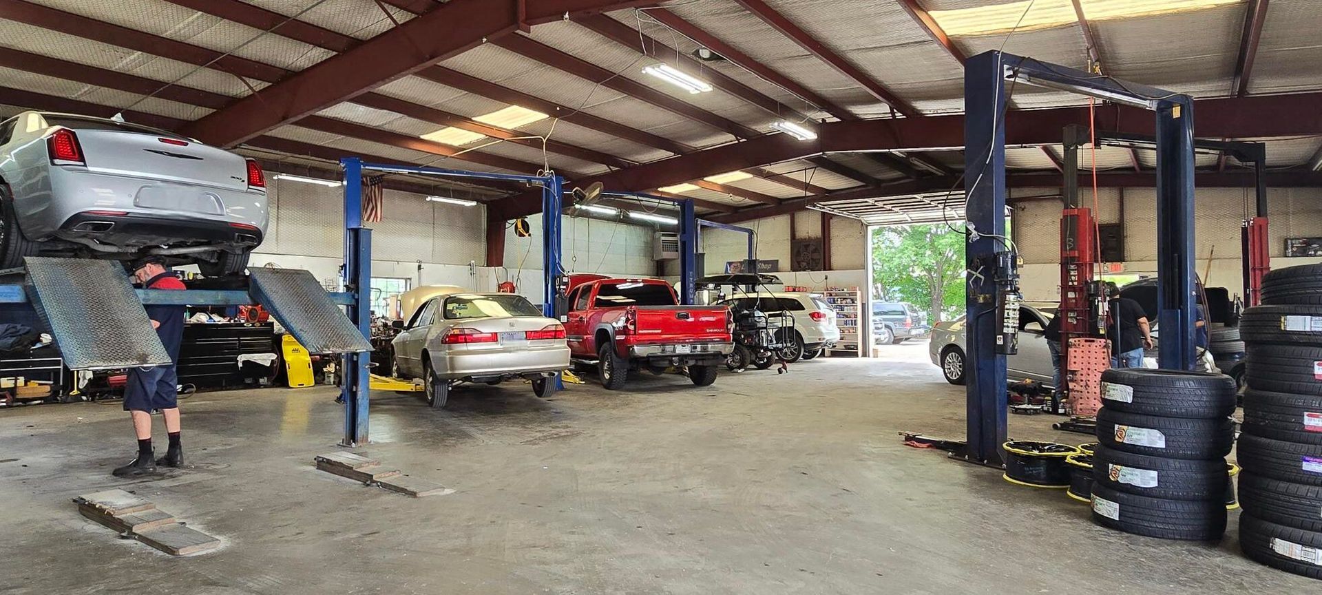 Interior View of Auto Repair Facility with Vehicles | Advanced Tire & Auto Service
