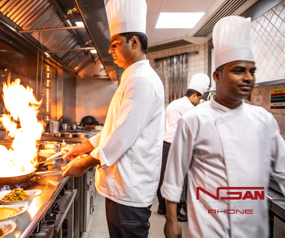 Un homme portant une toque de chef cuisine dans une cuisine