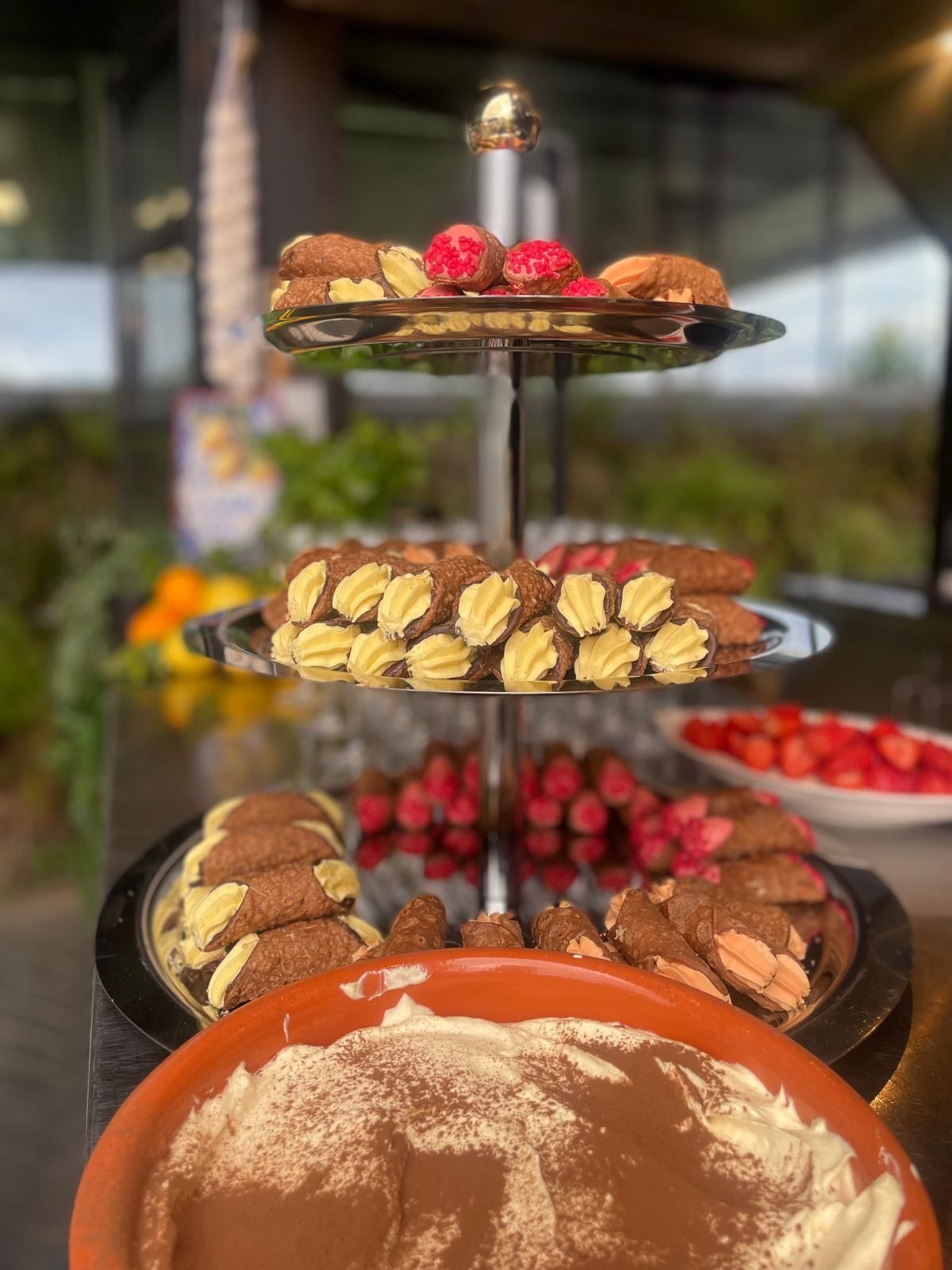 Een etagère met diverse gebakjes en tiramisu in een kom.