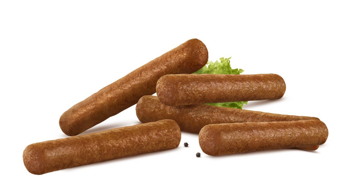 Een stapel bruine, cilindervormige frikandellen met een klein takje groene sla.