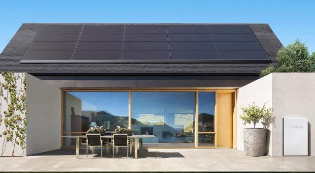 The exterior of an accessory dwelling unit (ADU) well-appointed with solar panels on its roof.